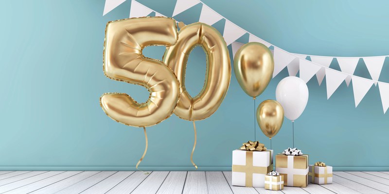 Geschenk zum 50. Geburtstag: goldene Ballonzahl 50 mit Wimpelkette und verpackten Geschenken