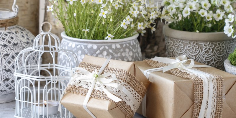 Geschenke zur Konfirmation: in Kraftpapier verpackte Geschenke mit Spitze und weißen Blumen